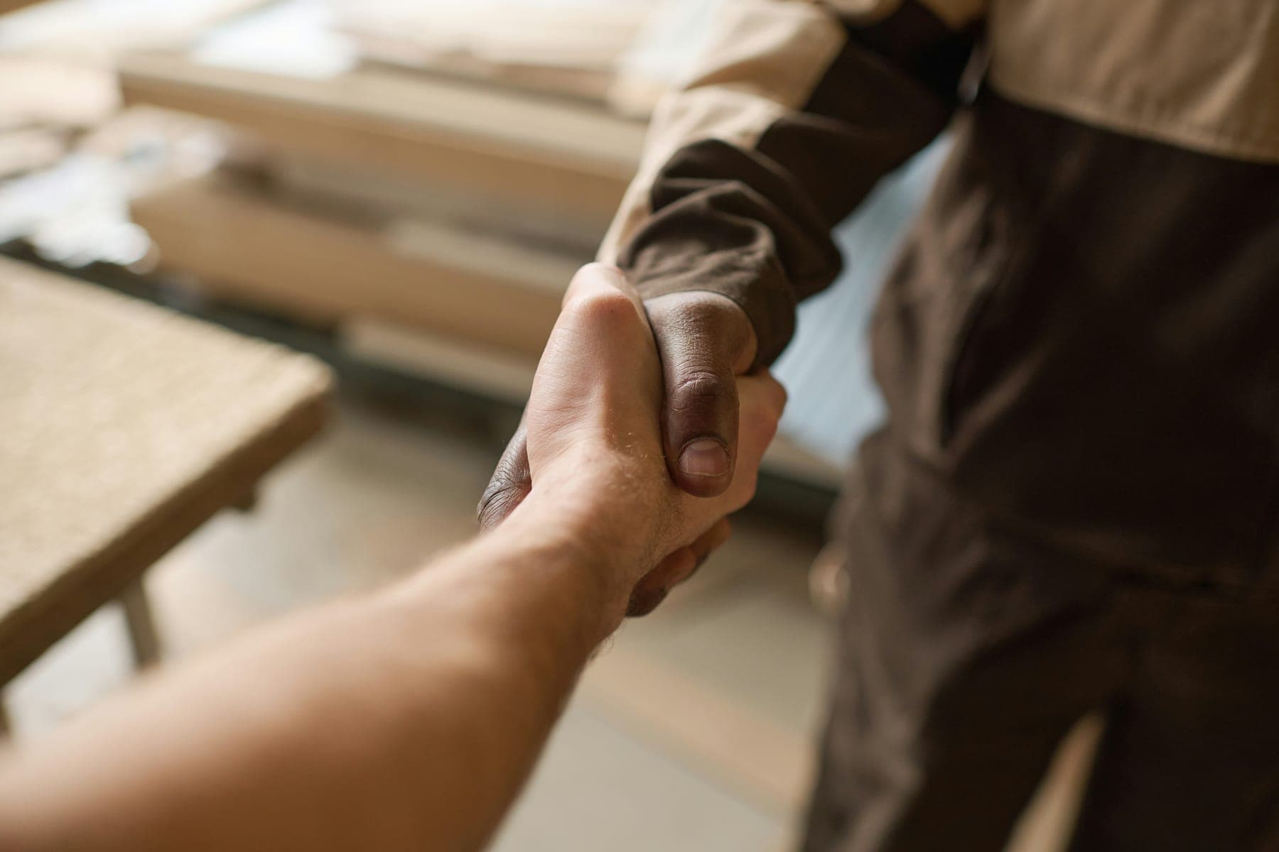 Handshake over a stack of building materials