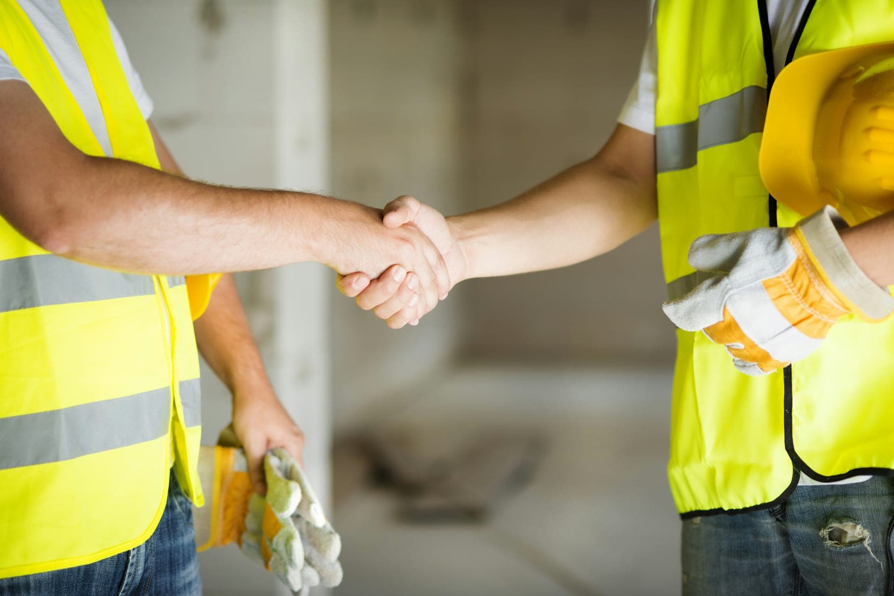 Two workers shaking hands inside a new build