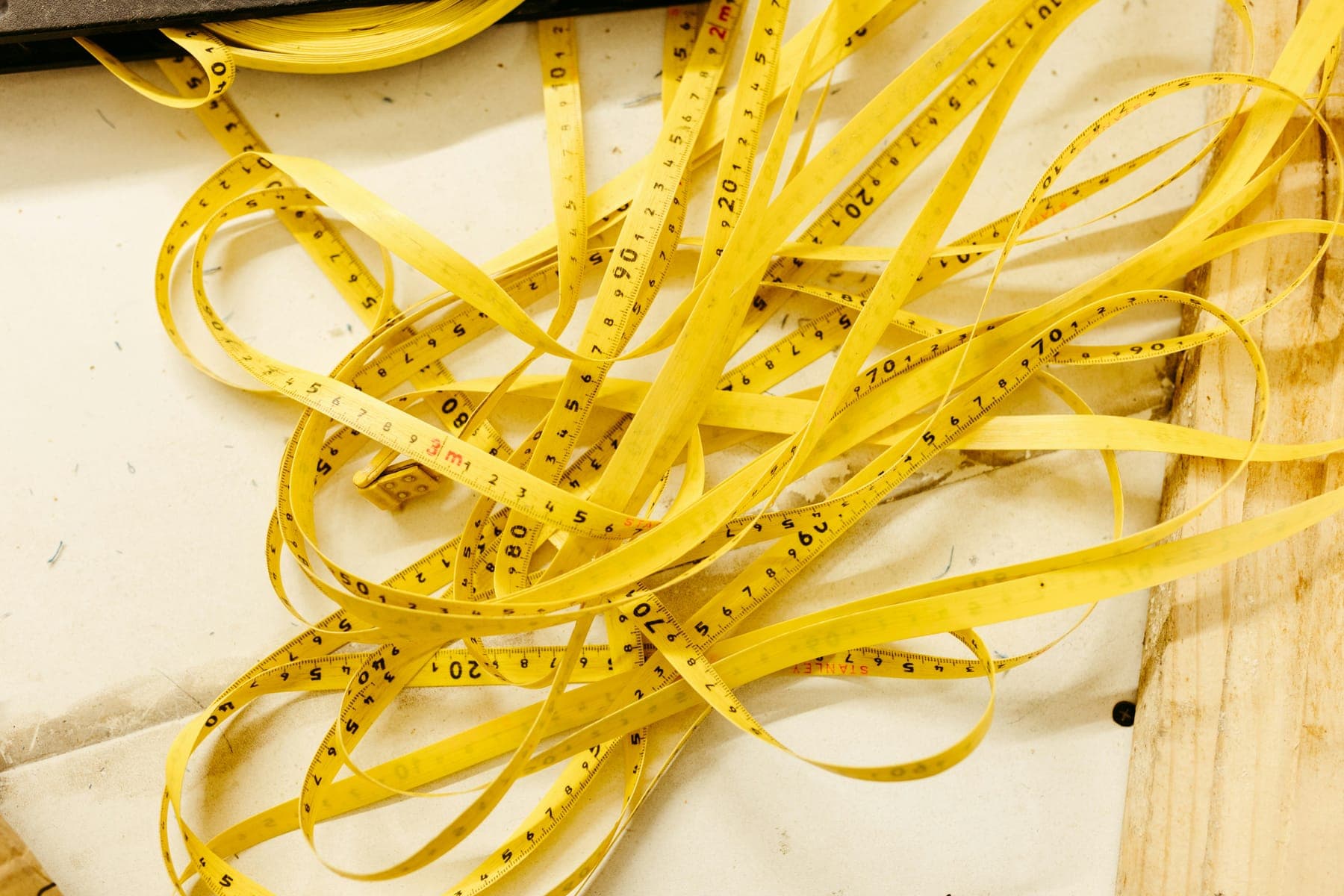 Yellow tape measures arranged edge to edge